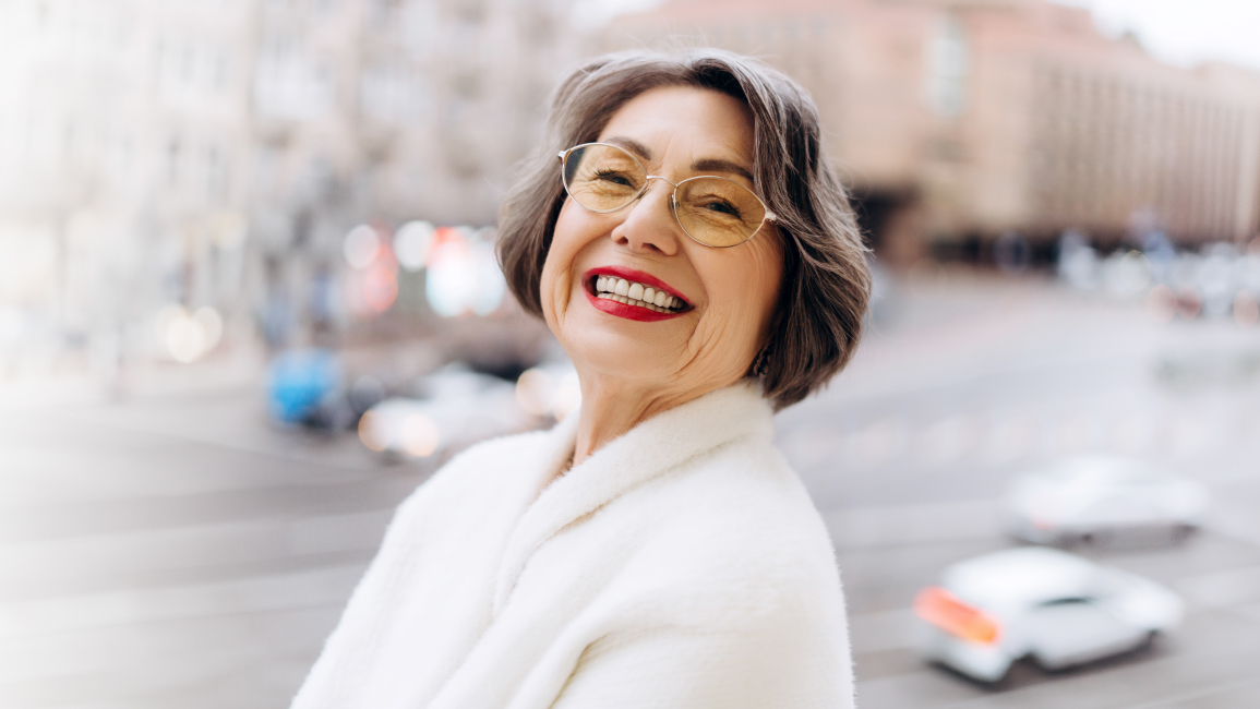 Senior woman smiling confidently after All-on-4 dental implants treatment